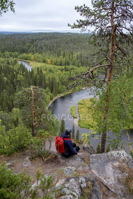 Finland, Oulanka National Park, woman with backpack sitting in pristine nature — Stock Photo