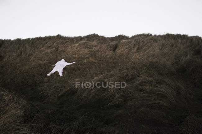 Danimarca, Nordjuetland, Uomo in costume da orso di ghiaccio sdraiato sull'erba — Foto stock