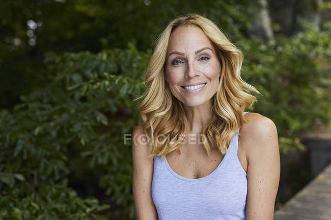 Portrait de femme blonde souriante à l'extérieur — Photo de stock