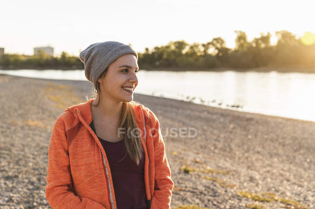 Ritratto di una giovane donna sportiva al fiume, con un cappello di berretto — Foto stock