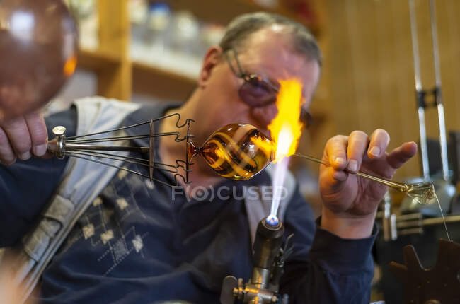 Glass blower forming melting glass — Stock Photo