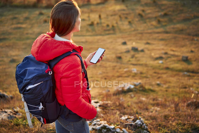 Frau mit Handy auf Wandertour in den Bergen — Stockfoto
