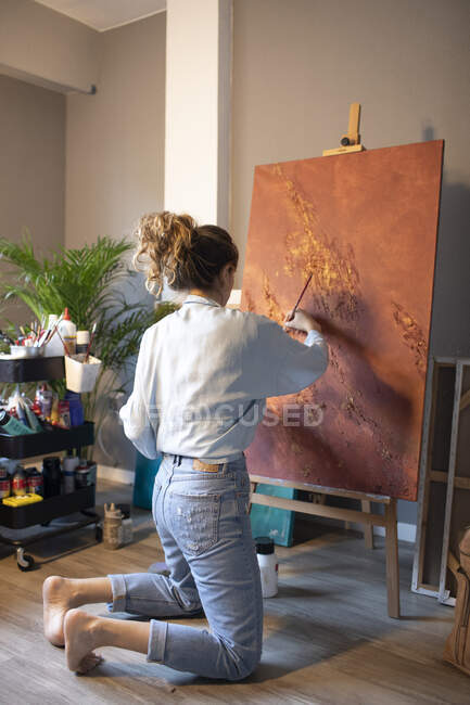 Молода жінка малює в своїй ательє. — стокове фото