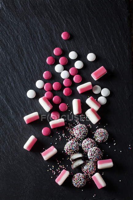 Various pink and white candies, peppermint candy, choclate buttons, fondant balls — Stock Photo