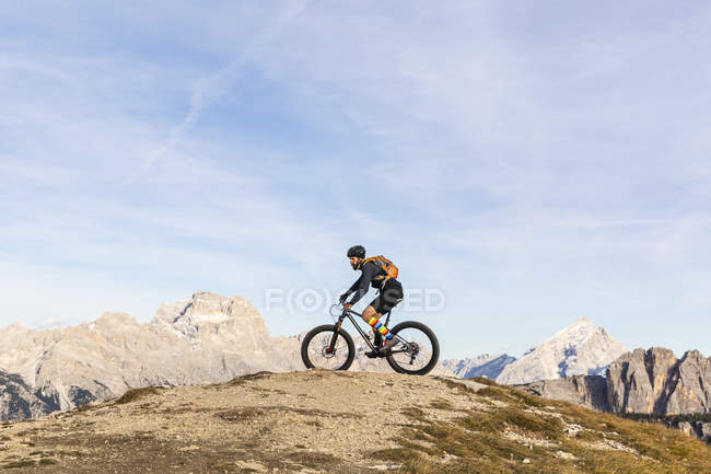 Italy, Cortina d 'Ampezzo, man cycling with mountain bike in the Dolomites mountains — стоковое фото