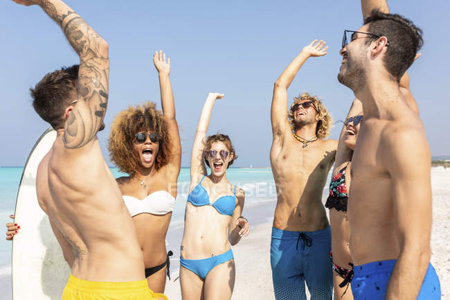 Щасливі друзі аплодують на пляжі — стокове фото