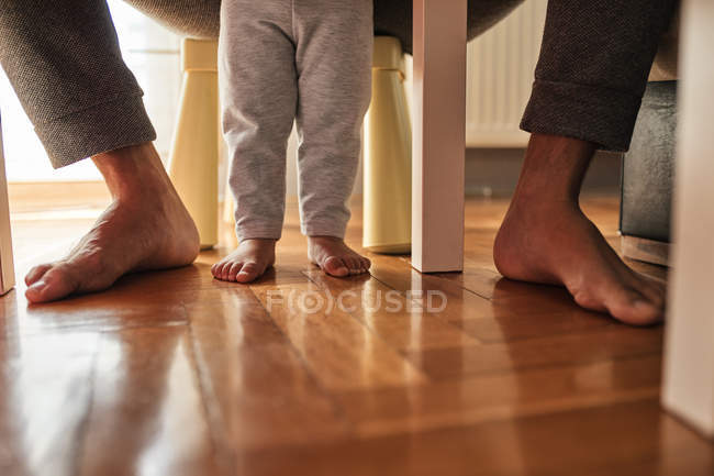 Imagem cortada de pai e filha descalça em parquet — Fotografia de Stock