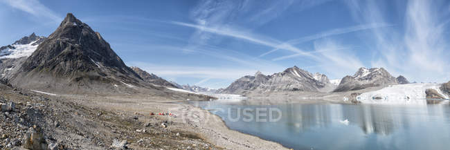 Groenlândia, Sermersooq, Kulusuk, Alpes Schwei=, acampamento de tendas na costa em paisagem montanhosa — Fotografia de Stock