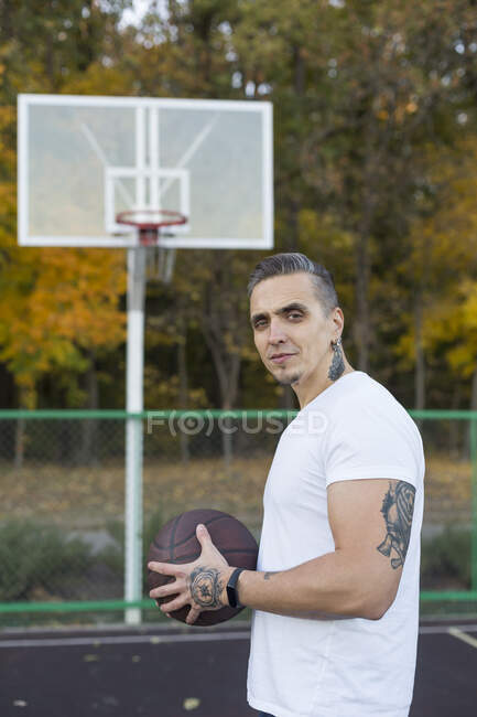 Portrait of man with basketball in autumn — Stock Photo