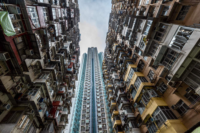 Hong Kong, Quarry Bay, bloques de apartamentos en contraste con el rascacielos moderno - foto de stock