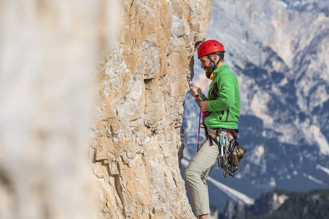 Italia, Cortina d'Ampezzo, uomo che fissa la corda mentre si arrampica sulle Dolomiti — Foto stock