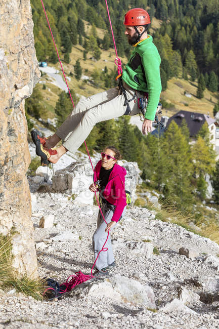 Italia, Cortina d'Ampezzo, uomo che scende sulle Dolomiti con l'aiuto di una donna — Foto stock