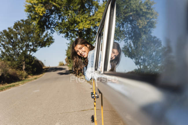 Mulher bonita em uma viagem de carro com seu campista, olhando para fora da janela do carro — Fotografia de Stock