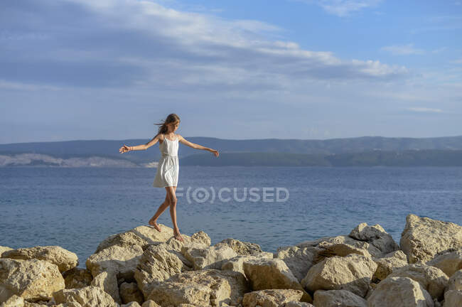 Croácia, Lokva Rogoznica, menina balancin descalço em rochas — Fotografia de Stock