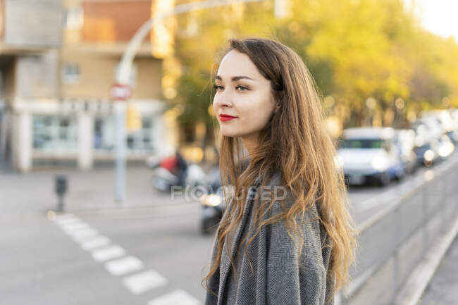 Junge Frau, die in der Stadt pendelt und eine Straße überquert — Stockfoto