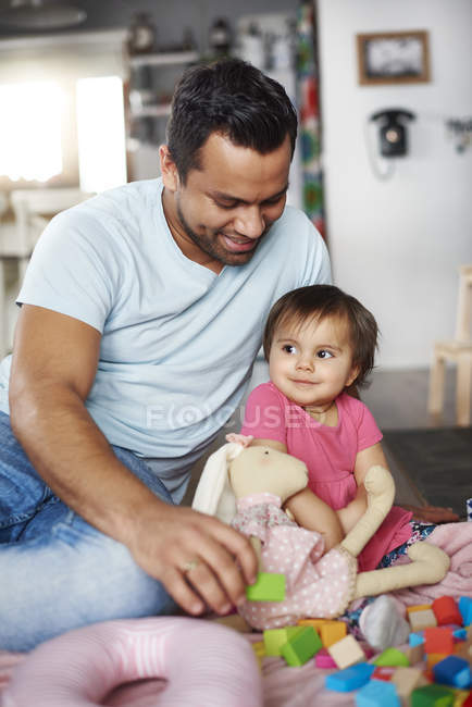 Sorrindo pai e bebê menina brincando com blocos de construção em casa — Fotografia de Stock