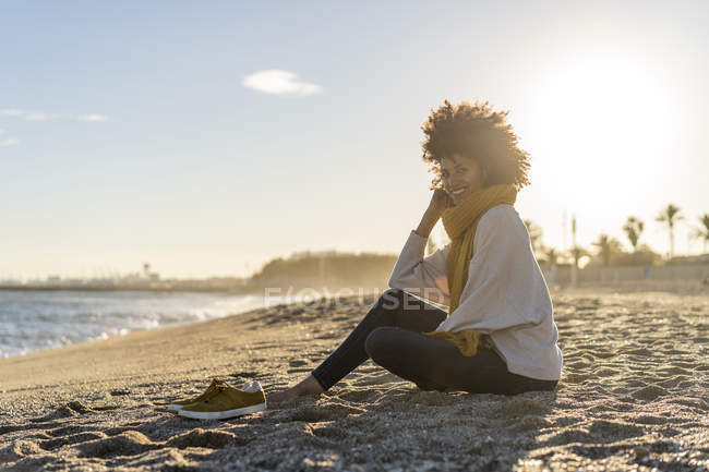 Woman sitting on the beach at sunset — Stock Photo