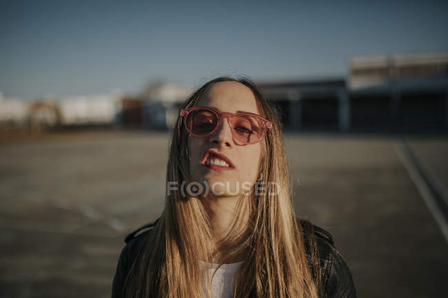 Retrato de jovem com atitude desafiadora usando óculos de sol ao ar livre — Fotografia de Stock