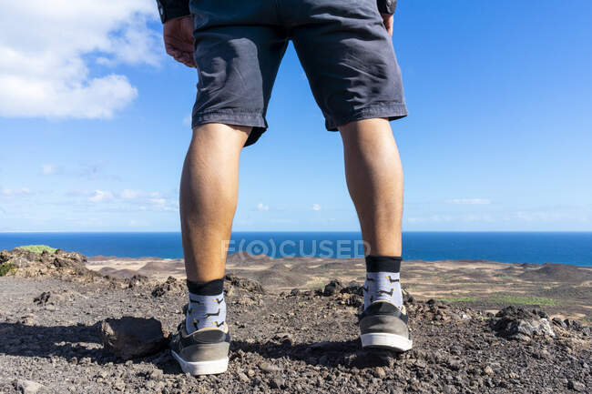 Espanha, Ilhas Canaray, Fuerteventura, pernas de um homem em pé na costa — Fotografia de Stock