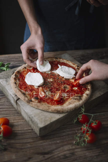 Двоє друзів готують піцу з моцарелою — стокове фото