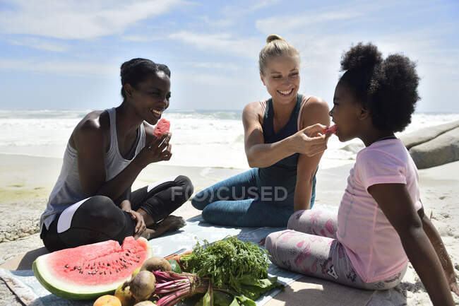 Мама з донькою та другом роблять пікнік на пляжі. — стокове фото