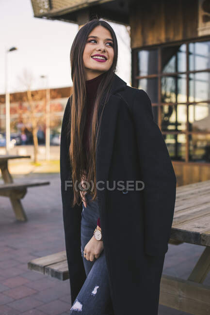 Портрет усміхненої дівчини - підлітка в чорному пальто. — стокове фото