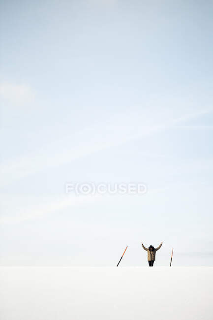Австрія, Мондсей, жінка з піднятими руками стоїть між двома брусами в зимовому ландшафті. — стокове фото
