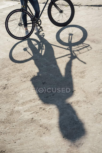 Primer plano del hombre con bicicleta de fijación de cercanías en losa de hormigón - foto de stock