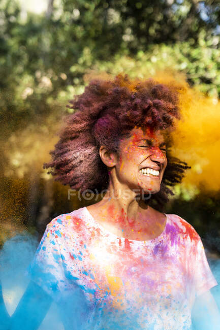 Mujer agitando la cabeza, llena de pintura en polvo de colores, celebrando Holi, Festival de Colores - foto de stock