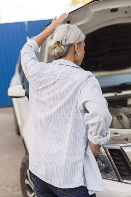 Rückansicht der Seniorin beim Anblick des Automotors — Stockfoto