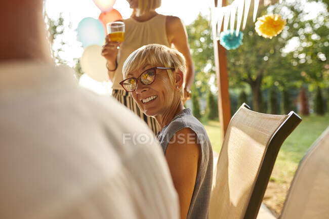 Sorrindo mulher madura olhando para o marido em uma festa de jardim — Fotografia de Stock