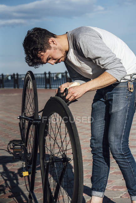 Young man repairing commuter fixie bike — Stock Photo