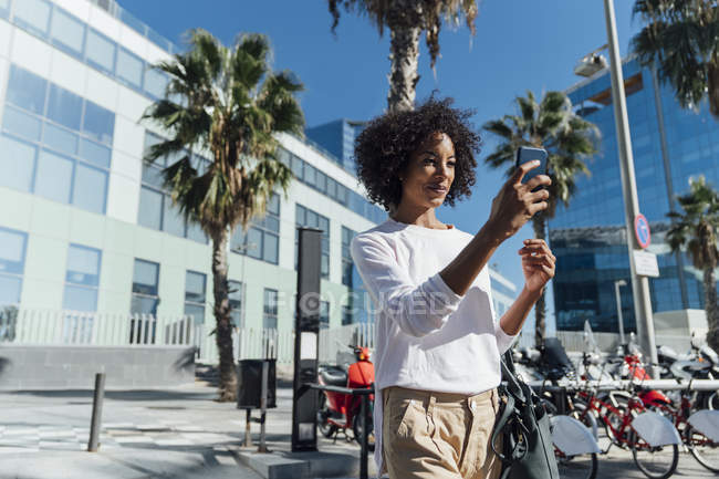 Junge Gelegenheitsunternehmerin in der Stadt mit Smartphone — Stockfoto