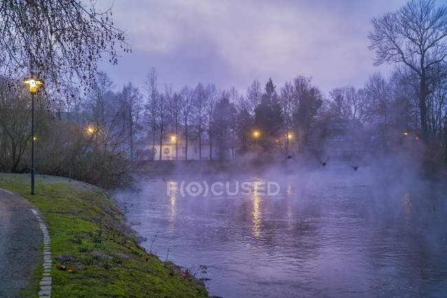 Alemania, Grevenbroich, el río Erft y la niebla en la noche - foto de stock