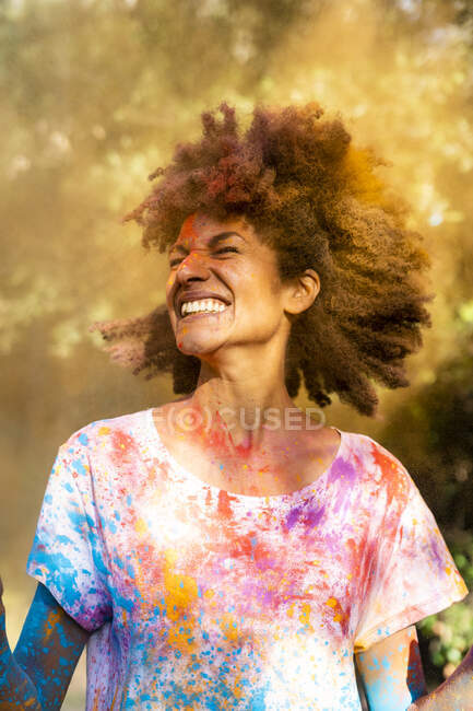 Donna scuotendo la testa, piena di vernice colorata a polvere, che celebra Holi, Festival dei Colori — Foto stock