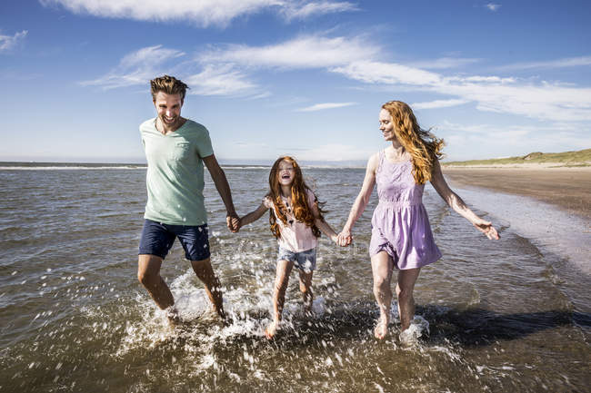 Netherlands, Zandvoort, happy family splashing in the sea — Stock Photo