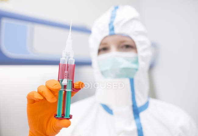Technicien de laboratoire portant une seringue de maintien en salle blanche — Photo de stock