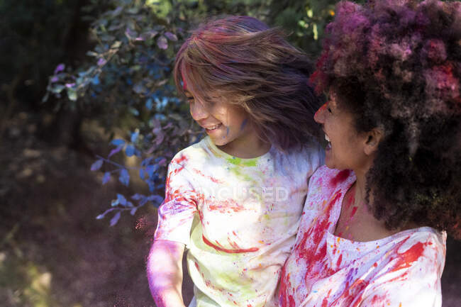 Madre e hijo llenos de pintura en polvo de colores, celebrando Holi, Festival de Colores - foto de stock