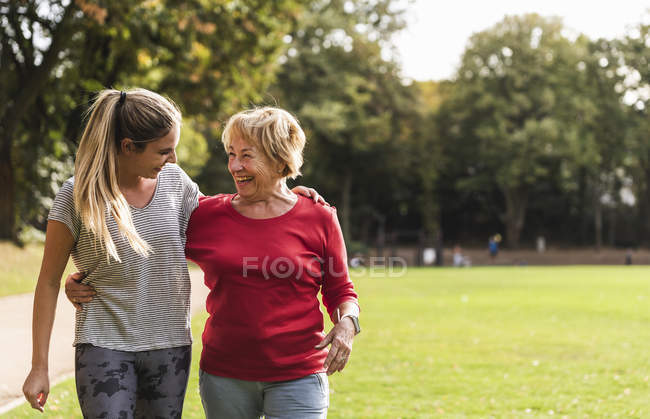 Granddaughter and grandmother having fun, jogging together in the park — Stock Photo