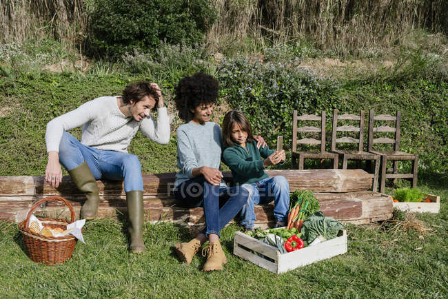 Famiglia felice prendersi una pausa dopo la raccolta di verdure, prendendo selfie — Foto stock