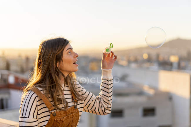 Удивительная молодая женщина смотрит большой мыльный пузырь — стоковое фото