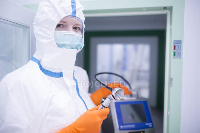 Tecnico di laboratorio che indossa un apparecchio di ritenuta generale in camera bianca presso la cagna materiale — Foto stock
