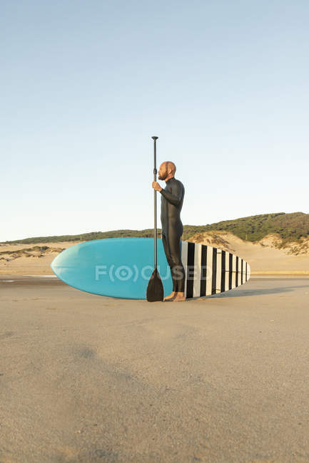 Espagne, Andalousie, Tarifa, homme avec planche à pagaie debout sur la plage — Photo de stock