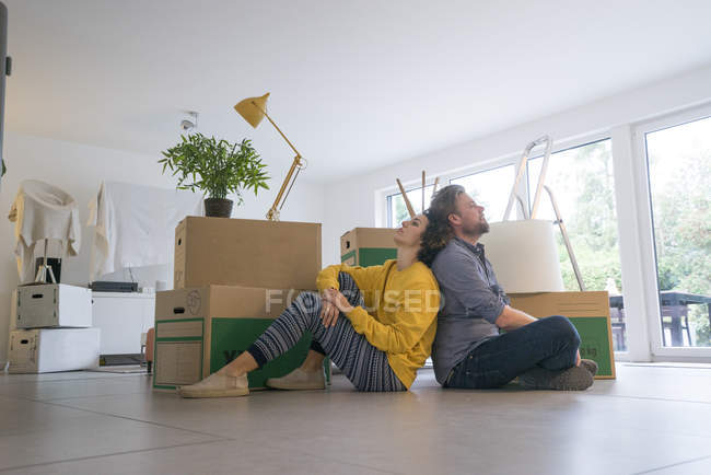 Coppia seduta in soggiorno con scatole di cartone — Foto stock