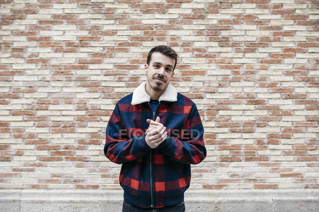 Junger Mann in lässiger Kleidung reibt sich die Hände und blickt in die Kamera — Stockfoto