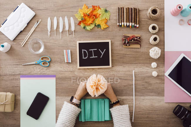Top view of young woman doing crafts with paper flowers in her studio — Stock Photo