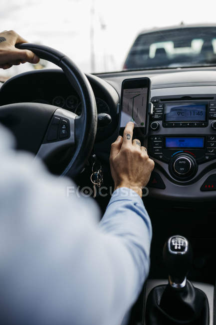 Close-up of man with tattooed hand driving car using cell phone as navigation system — Stock Photo