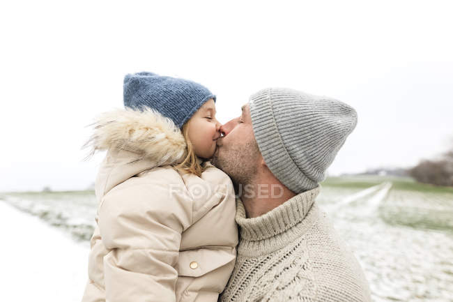 Pai beijando filha no inverno — Fotografia de Stock