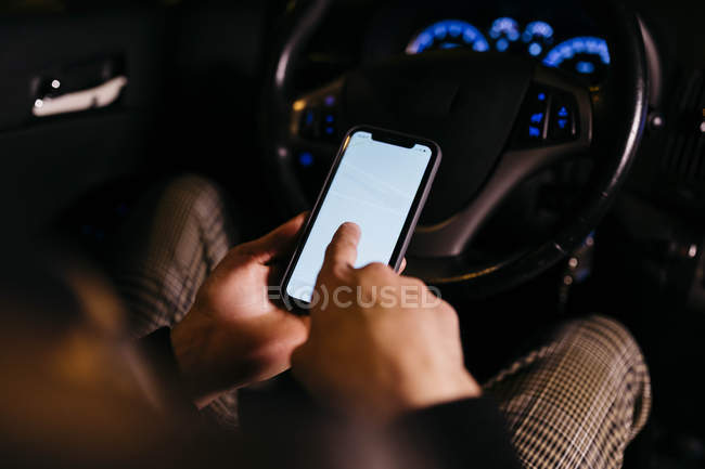 Man using cell phone in the car at night — Stock Photo