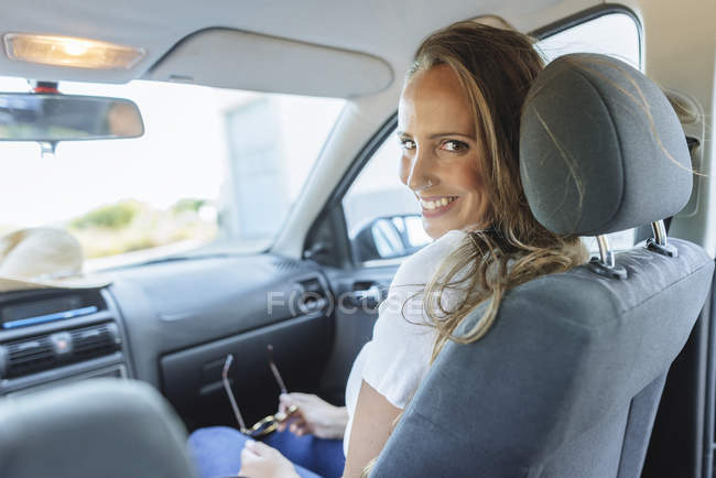 Portrait de sourire belle femme wappy sur le siège passager dans la voiture — Photo de stock